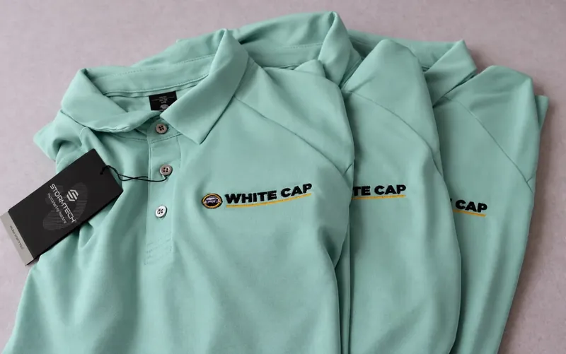Folded mint polos with a company logo embroidered on the chest