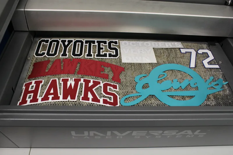 Laser-cut appliqué lettering, numbers and logos on the bed of a Universal laser cutter