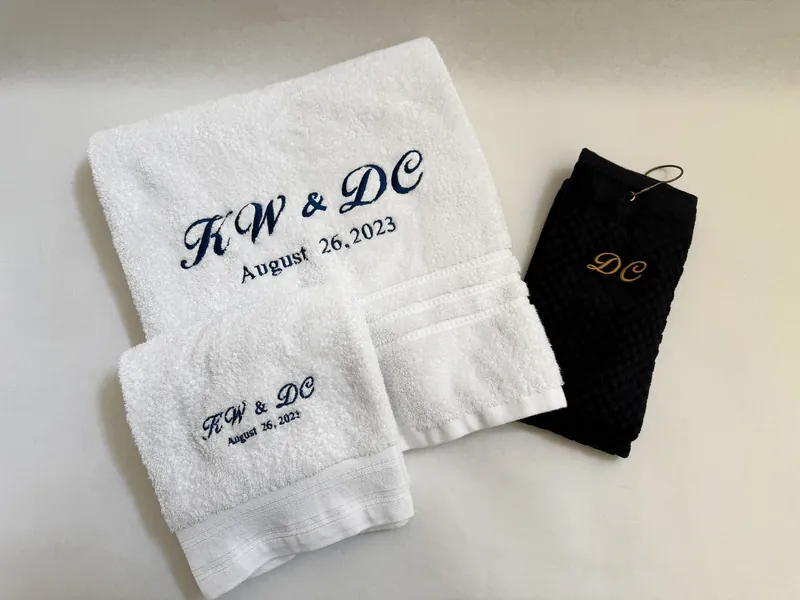 White towels with embroidered initials and a black golf towel