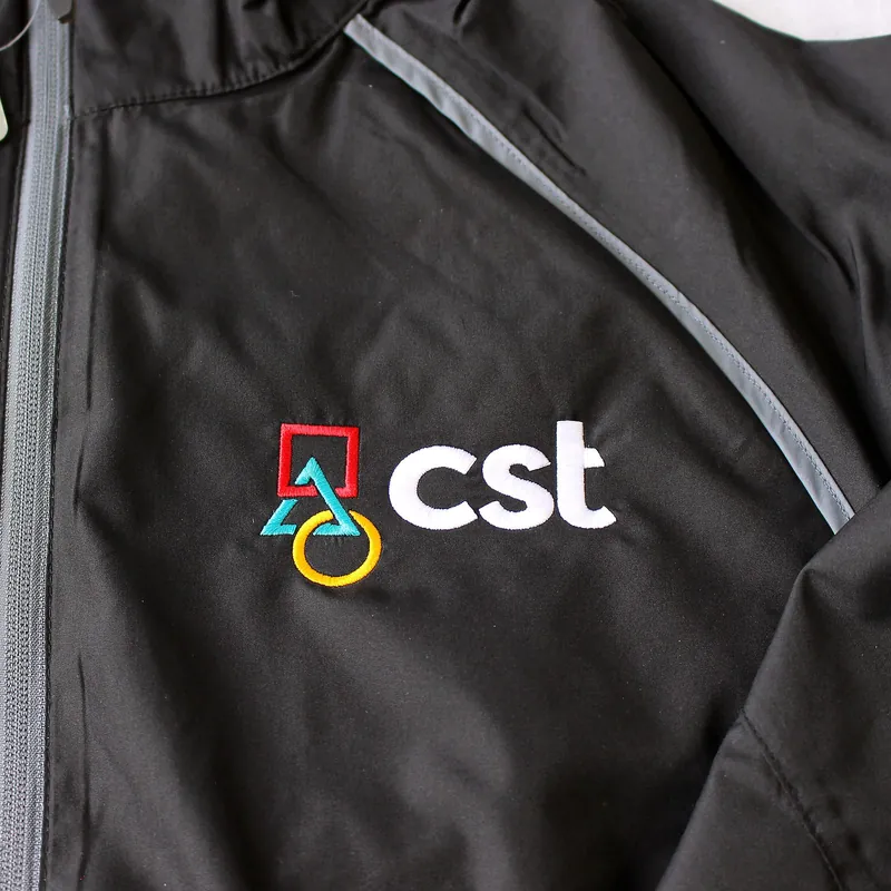 Logo stitched on the chest panel of a black work jacket