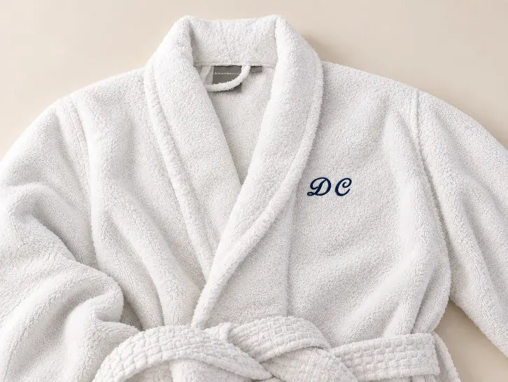 White robe with a script monogram on the chest