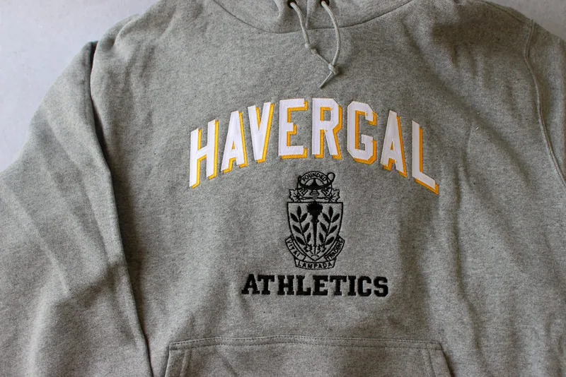 Grey hoodie with an applique school name and crest